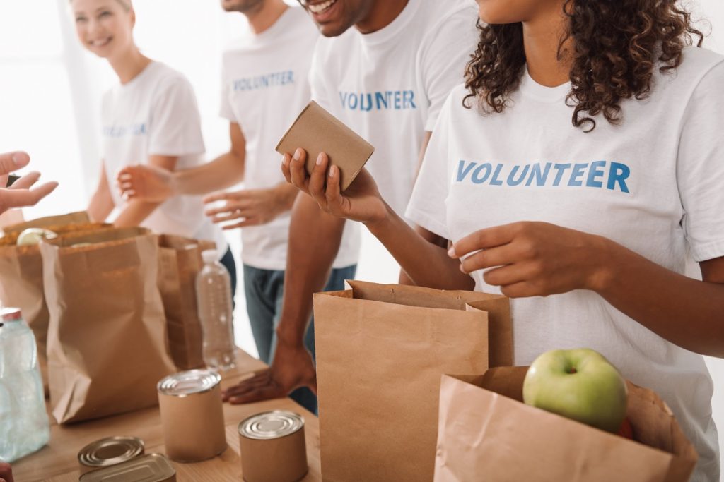 Volunteers giving goods to charity